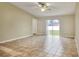 Open living room featuring tiled flooring, a ceiling fan, and sliding glass doors to the backyard at 7968 Charleston Blvd, Lakeland, FL 33810