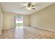 Spacious living room featuring tile flooring, a ceiling fan, and access to the backyard at 7968 Charleston Blvd, Lakeland, FL 33810