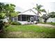 Landscaped backyard boasts a screened patio, manicured lawn, and mature trees, offering a serene outdoor retreat at 811 W Heron Pl, Winter Haven, FL 33884