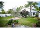 The landscaped backyard with screened-in porch, mature trees and garden beds enhances the outdoor living experience at 811 W Heron Pl, Winter Haven, FL 33884