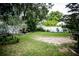Expansive backyard with lush lawn, mature trees, and privacy fence, offering ample space for outdoor activities and relaxation at 811 W Heron Pl, Winter Haven, FL 33884