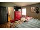 Comfortable bedroom featuring hardwood floors, a red dresser, and a door leading to another room at 811 W Heron Pl, Winter Haven, FL 33884