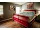 Cozy bedroom with hardwood floors, large windows, and a striking red sleigh bed for a comfortable retreat at 811 W Heron Pl, Winter Haven, FL 33884