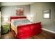 Bedroom with wooden floors, grey walls, a red bed frame, and a green nightstand at 811 W Heron Pl, Winter Haven, FL 33884