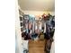 Walk-in closet with a wooden floor, packed with clothing, shelves, and storage boxes at 811 W Heron Pl, Winter Haven, FL 33884