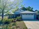 Charming single-story home with a well-maintained lawn, a large garage, and beautiful landscaping at 811 W Heron Pl, Winter Haven, FL 33884