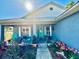 Inviting front porch with beautiful flowers and plants, seating and a bright green door at 811 W Heron Pl, Winter Haven, FL 33884