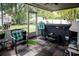 Covered porch with flagstone floors and a hot tub surrounded by seating and decor at 811 W Heron Pl, Winter Haven, FL 33884