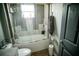 Bathroom featuring a shower-tub combo with glass doors and white tile surround at 811 W Heron Pl, Winter Haven, FL 33884