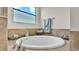 A soaking tub with tile surround, decorative candles and a towel rack at 1342 Heritage Landings Dr, Lakeland, FL 33805