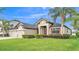 Charming home with a well-maintained lawn, mature landscaping, and a three-car garage at 1342 Heritage Landings Dr, Lakeland, FL 33805