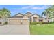 Attractive exterior with a well-manicured lawn, three-car garage, and lush landscaping at 1342 Heritage Landings Dr, Lakeland, FL 33805