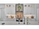 Close up of modern kitchen with white cabinetry, stainless steel appliances, decorative backsplash and under cabinet lighting at 1342 Heritage Landings Dr, Lakeland, FL 33805