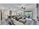 Open living room featuring a comfortable sectional sofa and view of a screened-in pool with lake views at 1342 Heritage Landings Dr, Lakeland, FL 33805