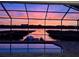 Screened pool area offers a scenic view of the lake at sunset at 1342 Heritage Landings Dr, Lakeland, FL 33805