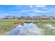 Scenic water view of homes, landscape, and beautiful, partly cloudy blue skies at 1342 Heritage Landings Dr, Lakeland, FL 33805