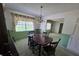 Dining room featuring a dark wood table, chandelier, green carpet and vintage decor at 1528 Hallam S Ct, Lakeland, FL 33813