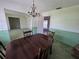 Traditional dining room featuring a wooden table, decorative chandelier, and light green accent wall at 1528 Hallam S Ct, Lakeland, FL 33813