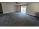 Spacious living room with neutral carpet, sliding glass doors, and ample natural light at 1528 Hallam S Ct, Lakeland, FL 33813