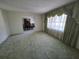 Bright living room featuring large windows and green carpet, adjacent to the dining area at 1528 Hallam S Ct, Lakeland, FL 33813