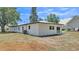 Back exterior view featuring white siding, dark trim, well maintained lawn and updated construction at 1650 W Mcleod St, Bartow, FL 33830