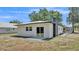 Exterior backyard showcasing white siding, dark trim, an outdoor patio, and a well-manicured lawn at 1650 W Mcleod St, Bartow, FL 33830
