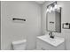 Bathroom featuring a toilet, a sink with white cabinets and a rectangle framed mirror with a light fixture above at 1650 W Mcleod St, Bartow, FL 33830