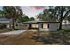 Charming single-story home with white facade, dark trim, and a welcoming screened-in porch at sunset at 1650 W Mcleod St, Bartow, FL 33830