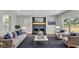 Cozy living room with a brick fireplace, hardwood floors, grey couches with blue pillows and natural light at 1650 W Mcleod St, Bartow, FL 33830