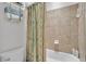 Cozy bathroom with a shower-tub combo, neutral tile, and ample shelving for storage at 1983 Via Lago Dr, Lakeland, FL 33810