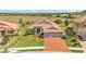 Beautiful single-story home featuring a red tile roof, brick driveway, mature landscaping, and a spacious lawn at 1983 Via Lago Dr, Lakeland, FL 33810