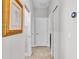 Well-lit hallway featuring neutral walls, tiled floors, and white doors for a clean, modern aesthetic at 1983 Via Lago Dr, Lakeland, FL 33810