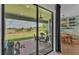 Covered patio with views of the backyard and green space beyond, accessed through sliding glass doors at 1983 Via Lago Dr, Lakeland, FL 33810