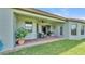 Covered patio with brick flooring, a ceiling fan, and a dining set surrounded by green grass at 1983 Via Lago Dr, Lakeland, FL 33810