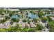 Aerial view of a residential neighborhood with a lake, lush trees, and modern homes under a bright blue sky at 4139 Cobblestone Dr, Lakeland, FL 33813