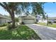 Charming home featuring an attached garage, lush green lawn, and mature trees providing shade on a sunny day at 4139 Cobblestone Dr, Lakeland, FL 33813