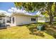 Backyard featuring a lush lawn, large tree, and the rear exterior of the house at 635 Cottage Ln # 635, Lakeland, FL 33803