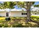 Backyard featuring a lush lawn, large tree, and the rear exterior of the house at 635 Cottage Ln # 635, Lakeland, FL 33803