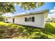 A single-story white home is captured from its backyard, with a grassy lawn in view at 635 Cottage Ln # 635, Lakeland, FL 33803