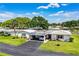 Charming home with a carport, green lawn, and well-maintained landscaping beneath a partly cloudy, blue sky at 635 Cottage Ln # 635, Lakeland, FL 33803