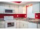 Kitchen showcasing granite countertops, range, microwave, and stainless steel sink at 635 Cottage Ln # 635, Lakeland, FL 33803