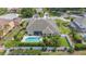Aerial view of the backyard showcasing a clear pool, spa, and fenced yard with lush, green landscaping at 715 Hanover Ct, Lakeland, FL 33813