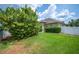 Spacious backyard with healthy green grass, trees and a privacy fence creating a peaceful outdoor setting at 715 Hanover Ct, Lakeland, FL 33813