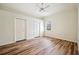 Bright bedroom with light wood flooring, white trim, fan, and large window at 715 Hanover Ct, Lakeland, FL 33813