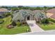 Charming single-story home featuring a well-manicured lawn and lush landscaping with elegant palm trees at 715 Hanover Ct, Lakeland, FL 33813