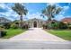 Stunning home showcasing a brick driveway and symmetrical design, complemented by mature landscaping and lush greenery at 715 Hanover Ct, Lakeland, FL 33813
