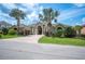 Beautiful single-story home with manicured lawn, brick driveway, and elegant palm trees in a friendly neighborhood at 715 Hanover Ct, Lakeland, FL 33813