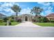 Beautiful front exterior with palm trees, well-manicured lawn, and a brick driveway at 715 Hanover Ct, Lakeland, FL 33813