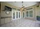 Covered lanai with tile flooring, ceiling fan, and multiple windows overlooking outdoor area at 715 Hanover Ct, Lakeland, FL 33813