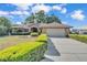 Charming brick home with a manicured lawn, mature landscaping, and a two-car garage at 7230 Hileman W Dr, Lakeland, FL 33810